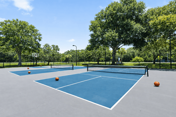 A blue tennis court with orange balls and a net.